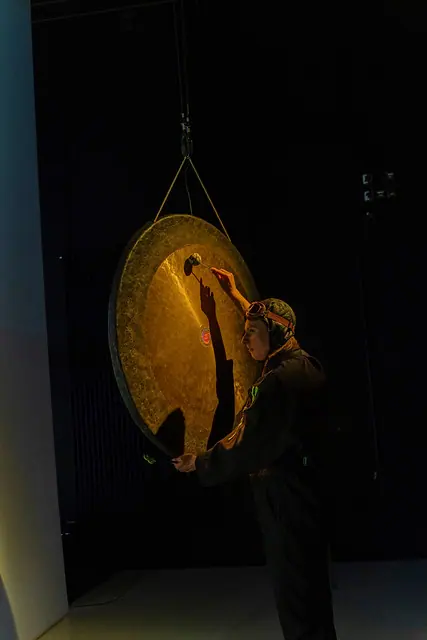 Gebärden der Geschichte mit Musikerin am großen Gong