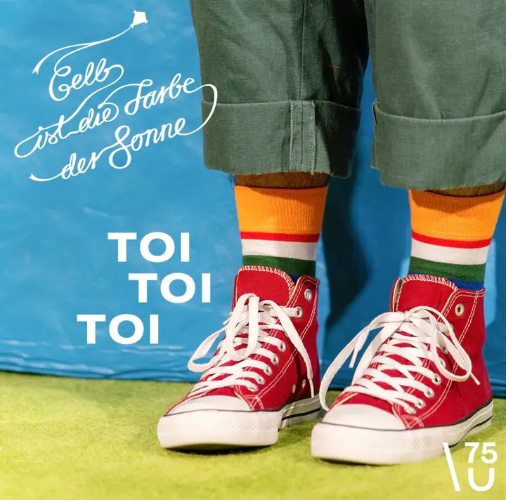 Gelb ist die Farbe der Sonne mit roten Schuhen und Schriftzug Toi Toi Toi